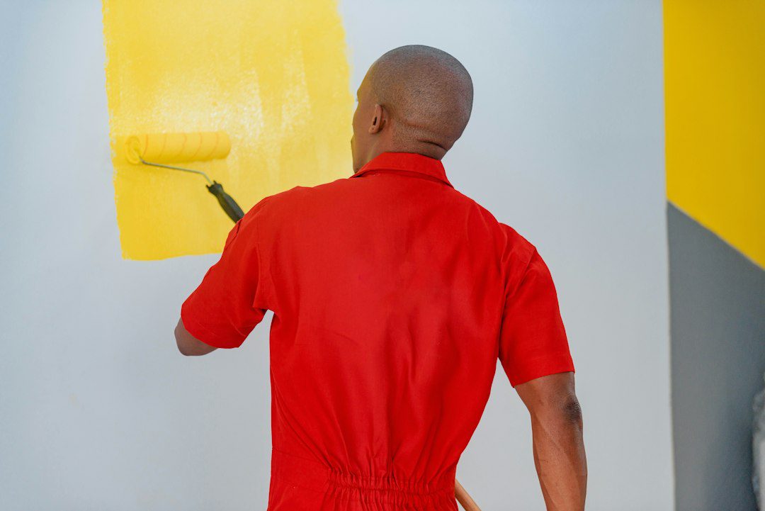 Person painting an interior wall with a roller