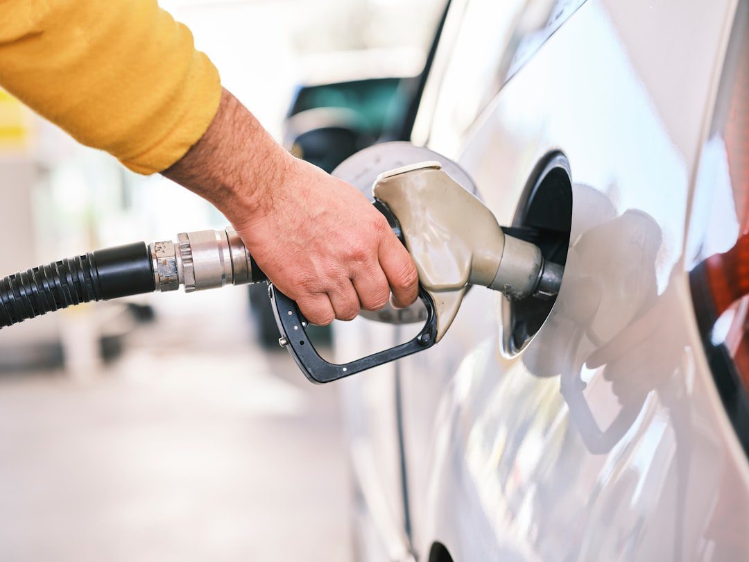 Person refueling a car at a gas station pump