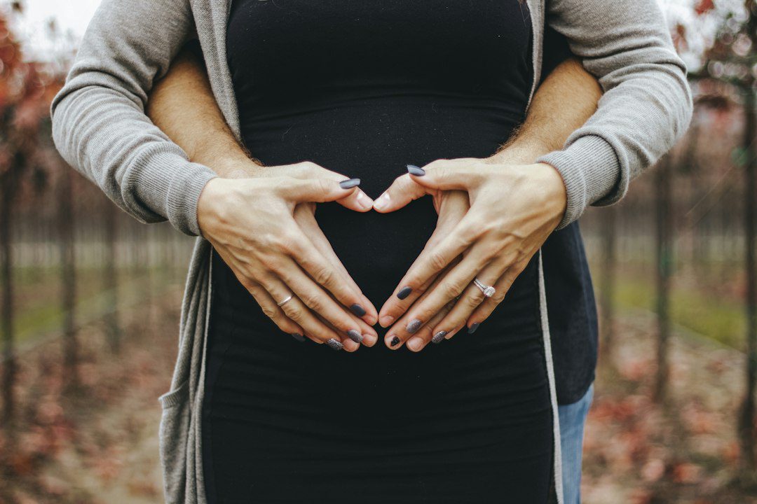 Woman gently holding her pregnant belly, for the Notchful pregnancy week calculator